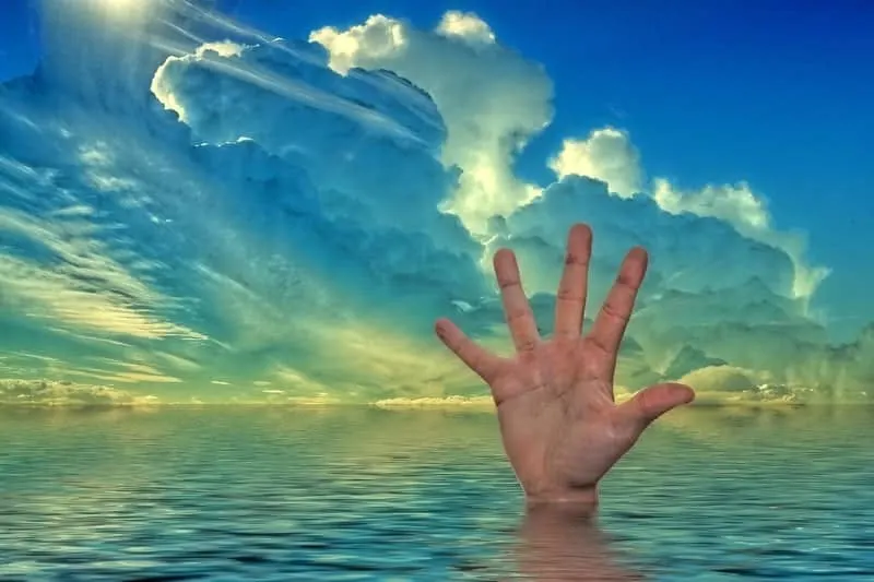 Hand sticking out of occean water