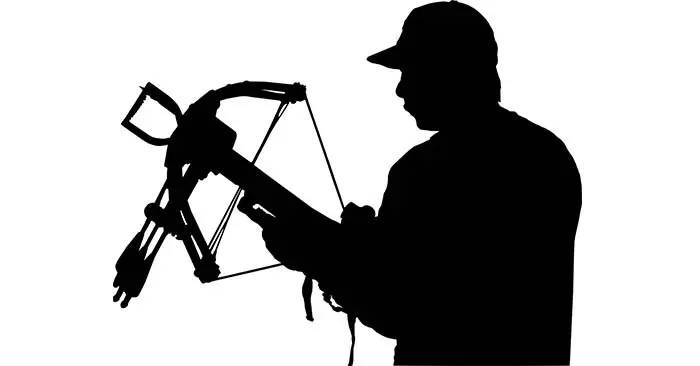 Silhouette of man ready to use his cross bow