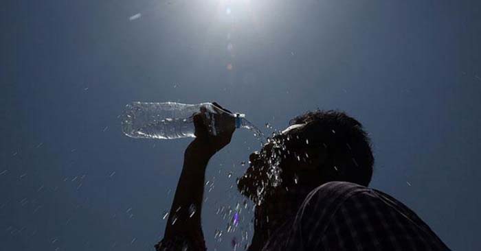 Man splashing water on his head to cool off