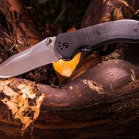 Survival knife on top of a wooden log