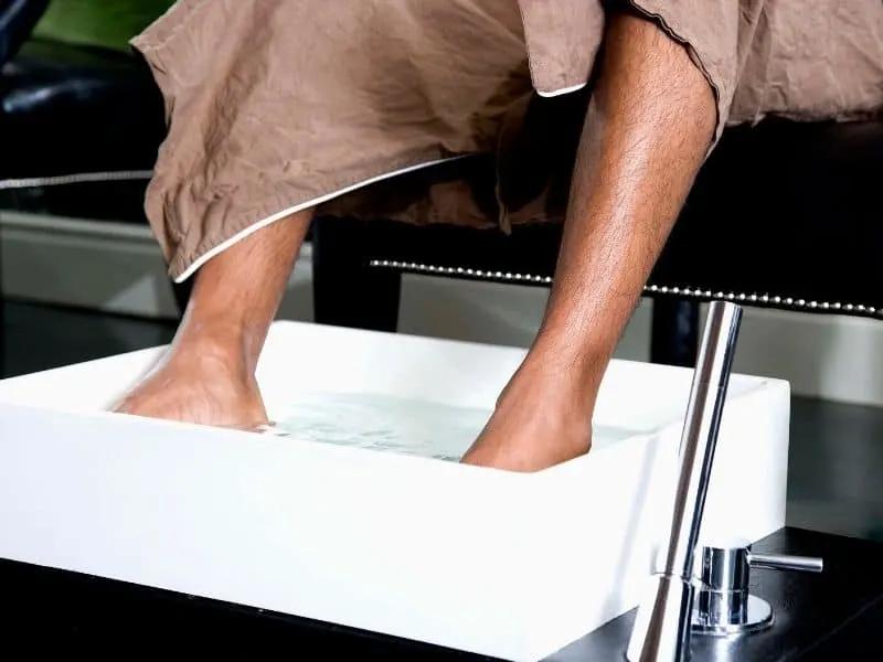 Man's feet soaking in vinegar and water soltution