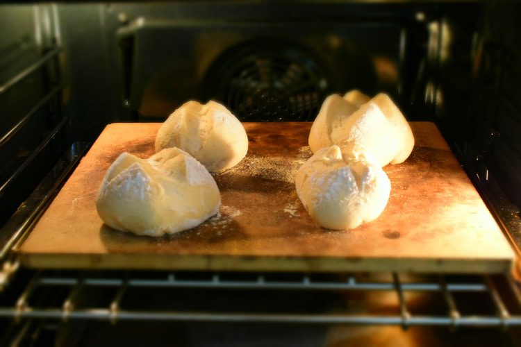 four small loaves of bread about to be baked