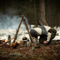 survivalist using bushcraft tools and skills