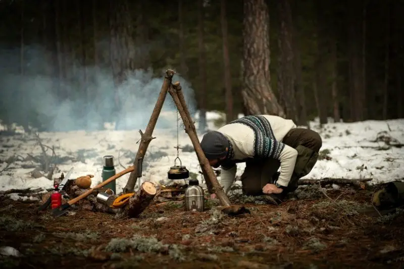 survivalist using bushcraft tools and skills