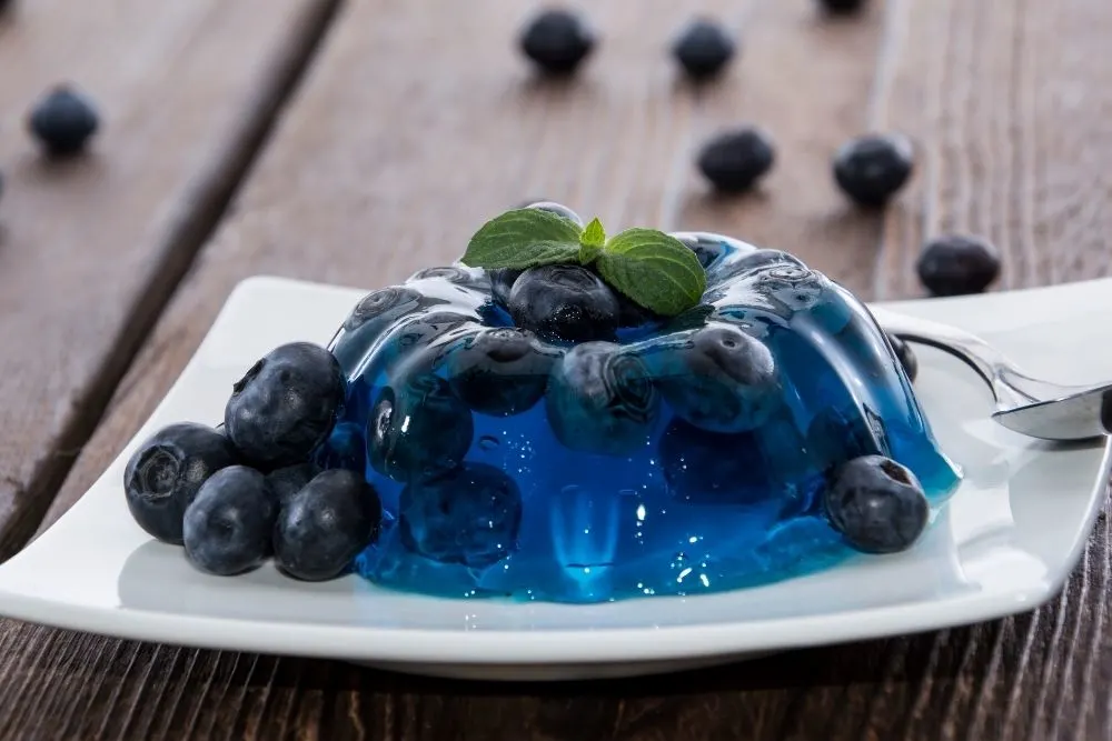 Blueberry jello on a plate with a spoon