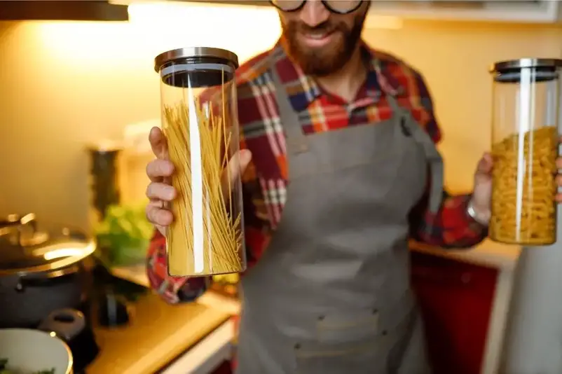 Man holding containers filled with pasta