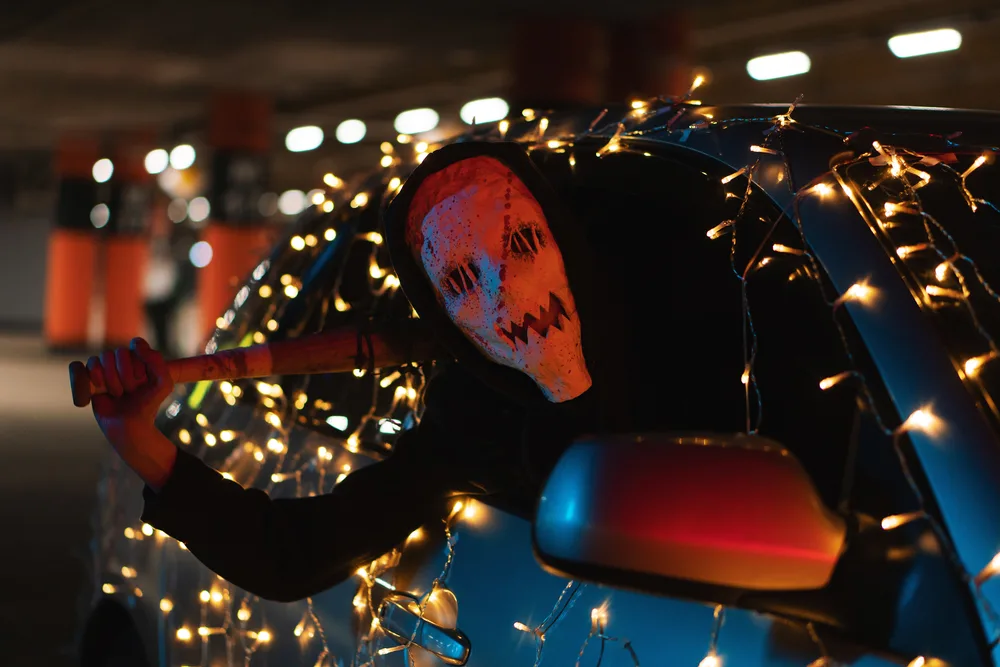 Masked Man Holding A Bat Inside A Car With Lights