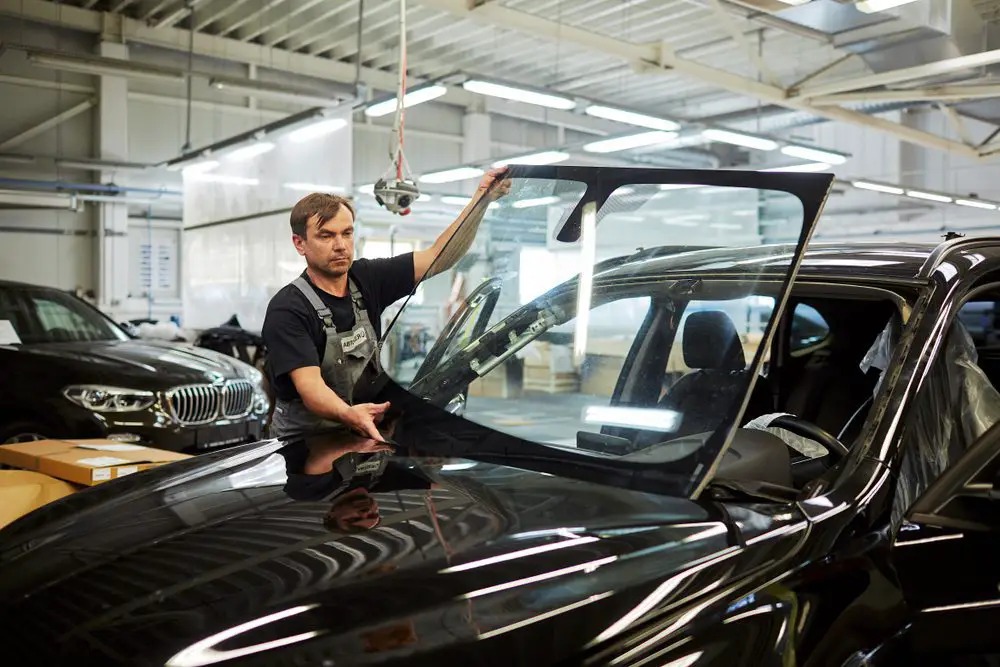 Men Putting Bulletproof Windshield On Car